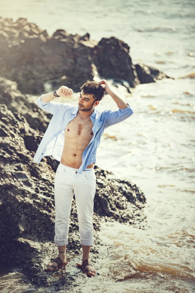 A young man in a stylish outfit posing outdoors.