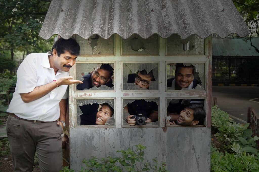 MDPS photography students and mentor Dharmesh Sachde participating in a creative conceptual photoshoot using a rustic structure with broken glass window panes.