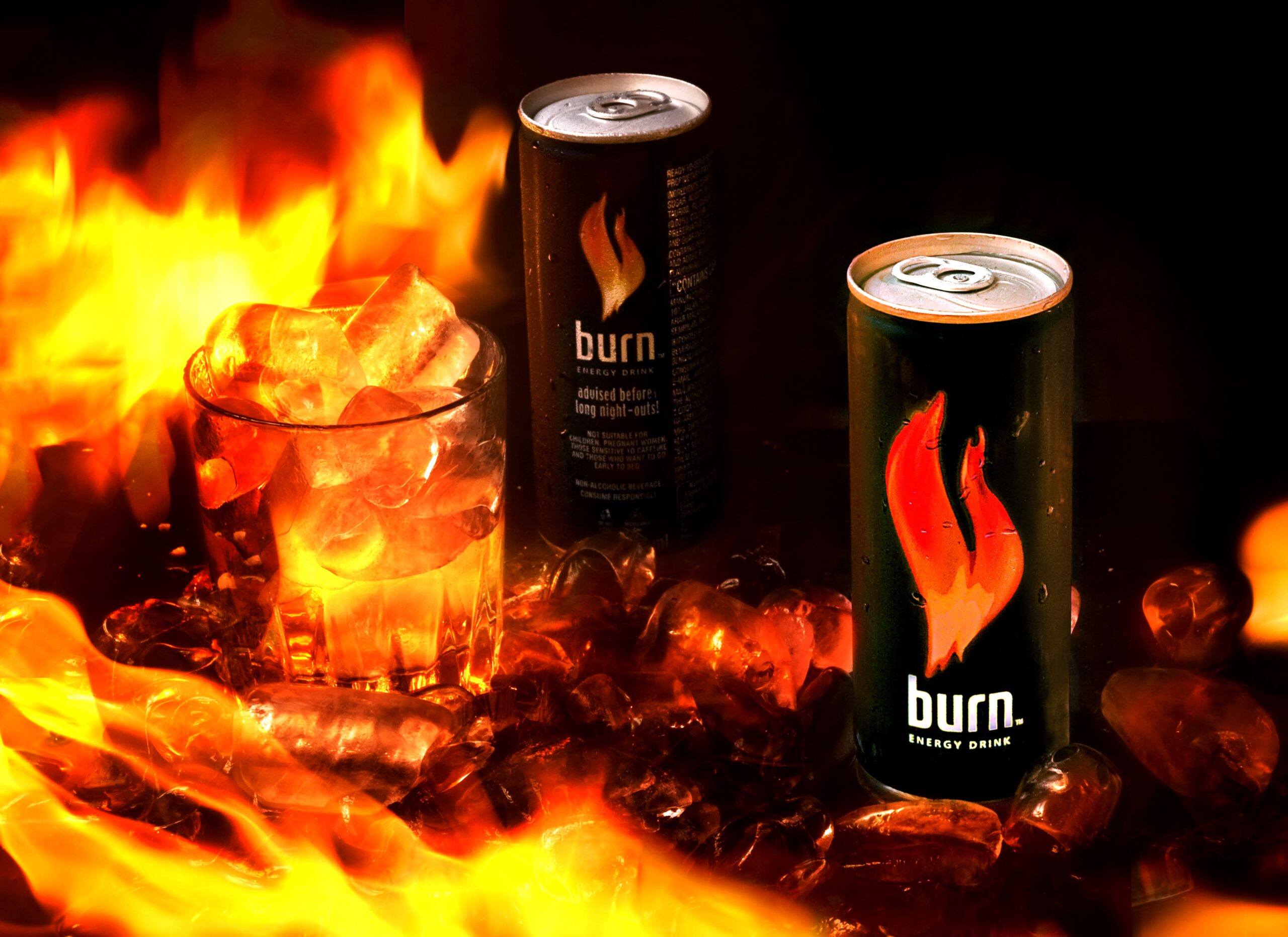 Two cans of Burn energy drink surrounded by flames and ice.