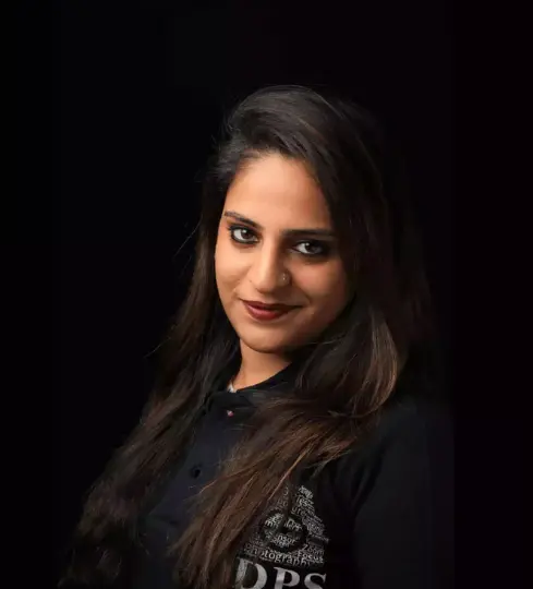 A professional portrait of Fatima Dharmesh Sachde, Director at MDPS, wearing a black shirt with the MDPS logo, against a dark background. Her expertise in photography and education is reflected in her confident stance.