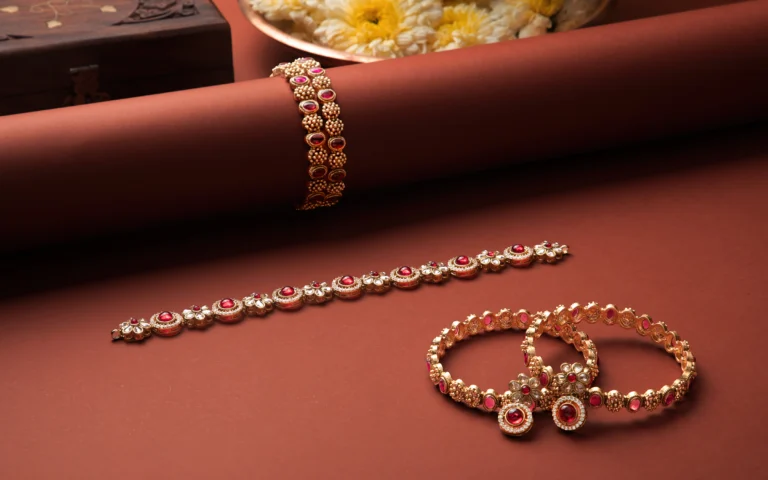 Student commercial jewelry photography project from MDPS featuring gold and ruby bangles styled on a warm brown background.