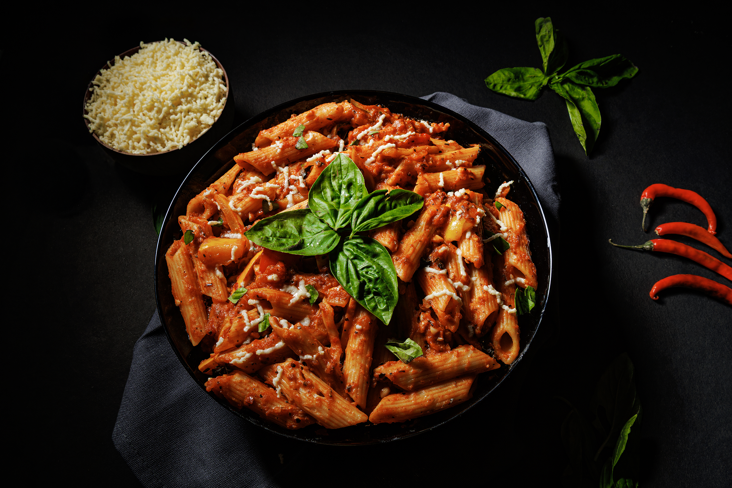 Student commercial food photography project from MDPS featuring a professionally styled penne pasta dish with dark, dramatic lighting.