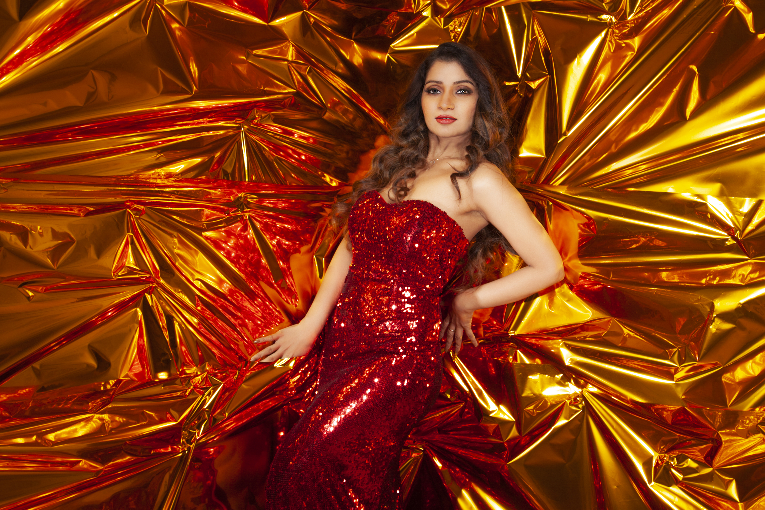 Student fashion photography project from the MDPS One-Year Master’s Programme featuring a model in a red gown against a gold reflective backdrop.