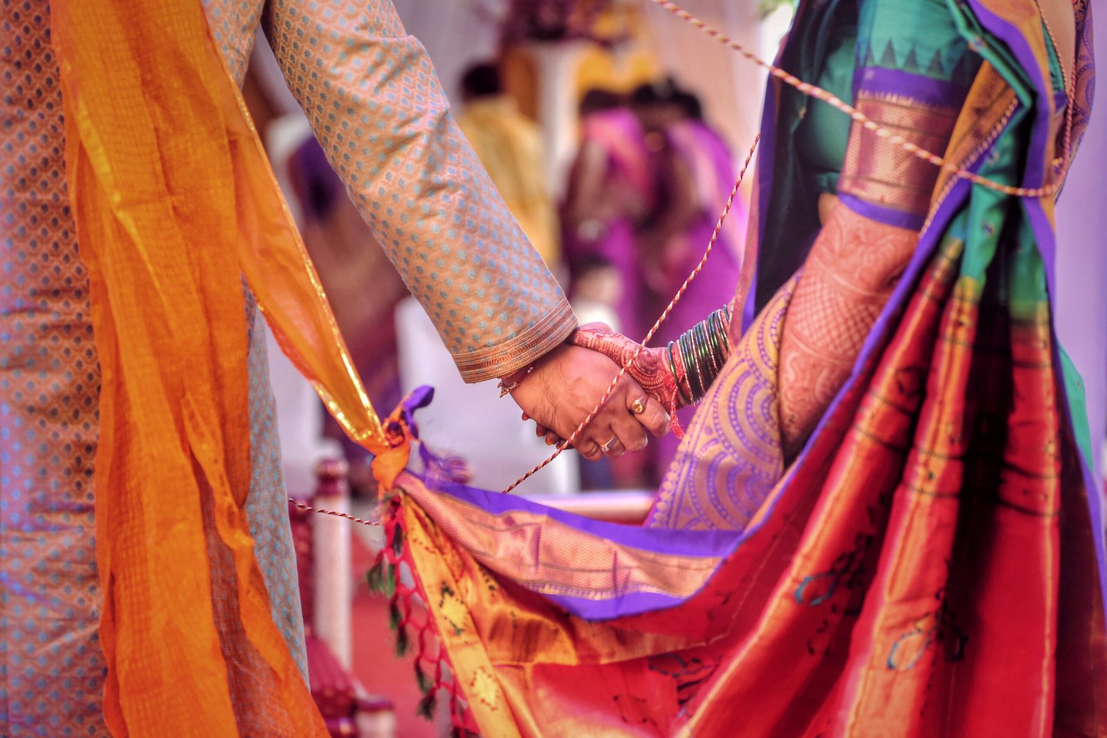 Wedding Photography Course student shot this symbolic close-up of a bride and groom holding hands during a traditional ceremony, highlighting themes of togetherness, trust, and their sacred knot.