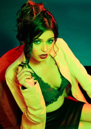 A Fashion Model posing for fashion photography course students in a gel lighting setup during the photography classes of MDPS